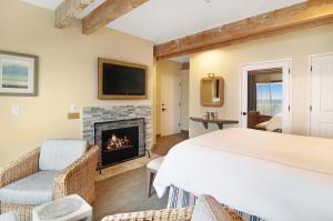 a living room with a fireplace and a bed at Cypress Inn on Miramar Beach in Half Moon Bay
