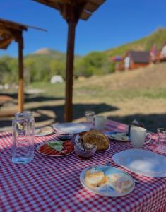 a table with plates of food on a red and white checked table cloth at Strofka in Maliq