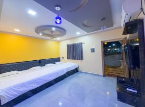 a bedroom with a large bed and a yellow wall at Advik Resort in Badlapur
