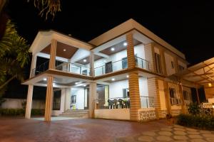 a house with people standing on the balcony at night at Advik Resort in Badlapur