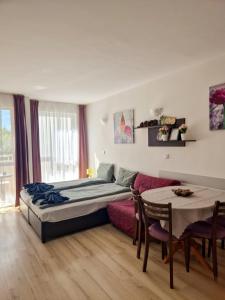 a bedroom with a bed and a table and a couch at Studio Kasandra in Hisarya
