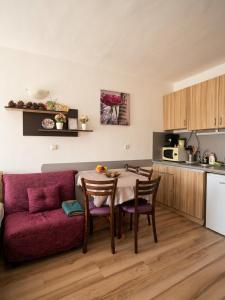 a kitchen with a table and a red couch at Studio Kasandra in Hisarya