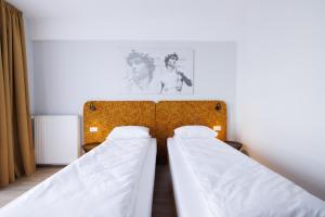 two twin beds in a room with a wall at Hotel Mariss in Alba Iulia