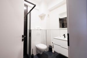 a white bathroom with a toilet and a sink at Hotel Mariss in Alba Iulia +15 photos