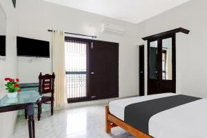 a bedroom with a bed and a desk and a window at Ocean Queen Palace Kovalam in Trivandrum