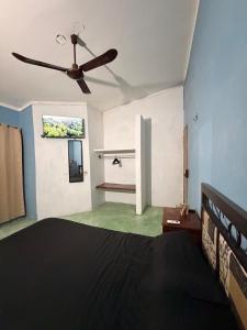 a bedroom with a bed and a ceiling fan at Pakal 2 Apartment in Palenque