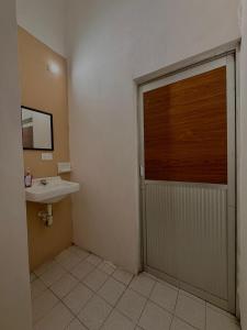 a bathroom with a door leading to a sink at Pakal 2 Apartment in Palenque