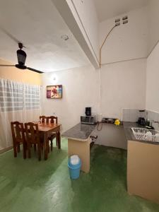 a kitchen with a table and chairs and green floors at Pakal 2 Apartment in Palenque