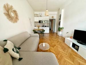 a living room with a couch and a kitchen at Bright and central suite with a balcony in Brno
