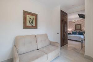 a living room with a white couch and a bedroom at Hotel Amapola La Barrosa in Novo Sancti Petri