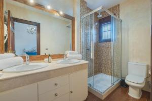 a bathroom with two sinks and a shower at Hotel Amapola La Barrosa in Novo Sancti Petri +30 photos