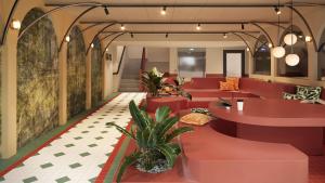 a lobby with red tables and potted plants at Bob W Vienna Döbling in Vienna