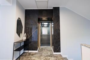 a hallway with black marble walls and a elevator at Hotel Mariss in Alba Iulia