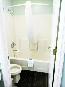 Hearthstone Inn في Lafayette: حمام مع مرحاض وحوض استحمام