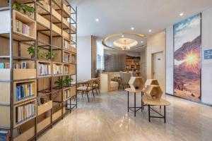 a library with tables and chairs and bookshelves at Atour Hotel (Urumqi Renmin Cinema) in Ürümqi