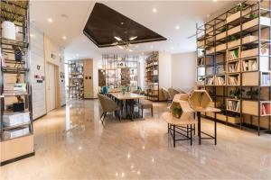 a library with a table and chairs and bookshelves at Atour Hotel (Urumqi Renmin Cinema) in Ürümqi