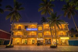 a hotel with palm trees in front of it at FabHotel Shadowline in Goa