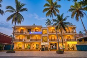 a hotel with palm trees in front of it at FabHotel Shadowline in Goa