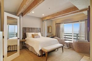 a hotel room with a large bed and a large window at Cypress Inn on Miramar Beach in Half Moon Bay