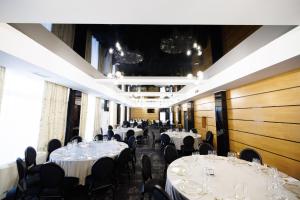a banquet hall with white tables and black chairs at Hotel Mariss in Alba Iulia