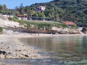 a group of people on a beach near the water at Klimatsias Beach Apartment in Pesádha +8 photos