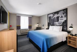 a hotel room with a large bed and a flat screen tv at Super 8 by Wyndham Warrenton in Warrenton