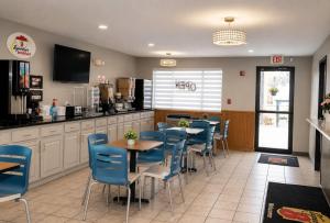 a restaurant with blue chairs and tables and a counter at Super 8 by Wyndham Warrenton in Warrenton