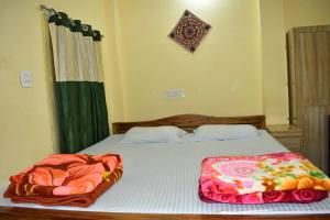 a bedroom with two beds and a window with a bedspread at Bhitarkania Riverside Eco Resorts in Righāgarh
