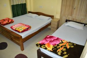 two beds in a room with two beds sidx sidx sidx at Bhitarkania Riverside Eco Resorts in Righāgarh +43 photos