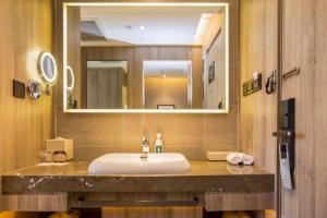 a bathroom with a sink and a large mirror at Atour Hotel (Urumqi Renmin Cinema) in Ürümqi +29 photos