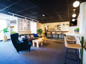 a living room with a couch and a table at Novotel Saint Avold in Saint-Avold