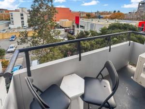 two chairs on a balcony with a view of a city at Right in Fremantle in Fremantle