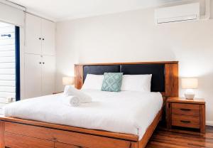 a bedroom with a large bed with a wooden headboard at Esplanade Views Heart of Freo Family Stay in Fremantle