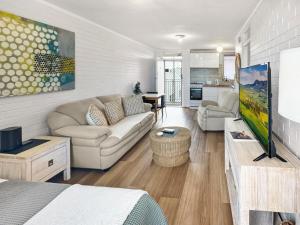 a living room with a couch and a tv at Right in Fremantle in Fremantle
