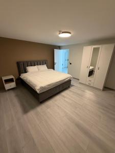 a bedroom with a large bed and a wooden floor at Vila Handžić in Mostar