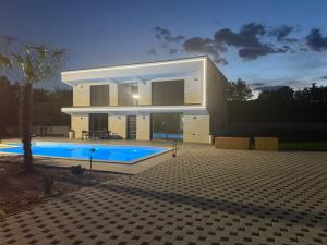 a house with a swimming pool in front of it at Vila Handžić in Mostar