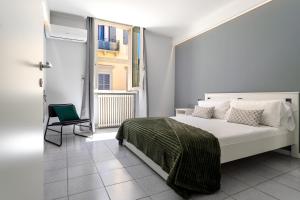 a bedroom with a bed and a chair and a window at Bandiera Urban House in Lanciano
