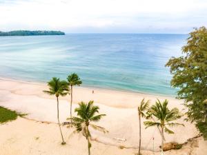 a view of a beach with palm trees and the ocean at Cassia Residence by Metrika, Laguna Phuket in Laguna Phuket +25 photos