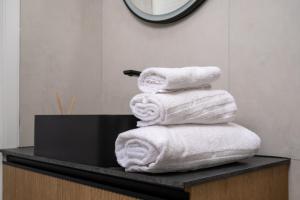 a stack of towels sitting on a counter in a bathroom at Bandiera Urban House in Lanciano +38 photos