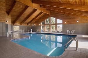 a large swimming pool with tables and chairs at AmericInn by Wyndham Baldwin in Baldwin