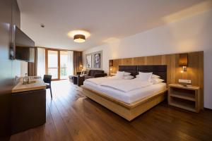 a bedroom with a large bed and a living room at Das Kronthaler - Adults only in Achenkirch +64 photos