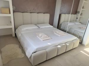 a white bed in a room with a mirror at Villa Lenuska in Quartu SantʼElena +20 photos