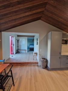 an open living room with a wooden ceiling at Sjöstugan in Leksand