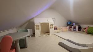 a attic room with a bed and a play house at South Sagye Jeju in T'ogi-dong