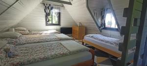 a room with three beds and two windows at Chata Pietraszyna in Koniaków