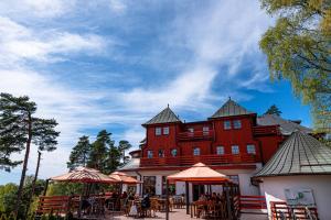 a large red building with tables and umbrellas in front at CAMP VARY - Vítkova Hora in Karlovy Vary
