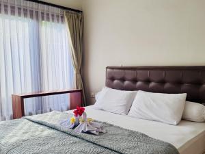 a bed with a doll sitting on top of it at Noble Bali Diving Resort Tulamben in Tulamben