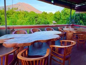 a table and chairs with a view of a mountain at Noble Bali Diving Resort Tulamben in Tulamben +1 photo