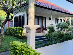 a house with a porch and stairs leading to it at Noble Bali Diving Resort Tulamben in Tulamben