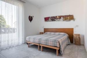a bedroom with a bed with a plaid blanket and a window at Agriturismo da Natalino in Ceggia